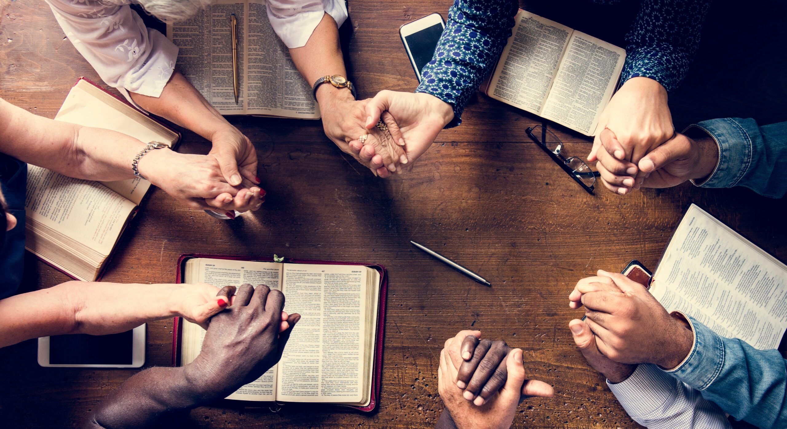 Group of people holding hands praying worship believe